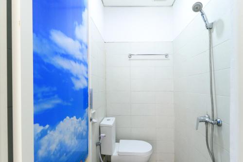 a bathroom with a toilet with a blue sky painted on the wall at Donata House in Jimbaran