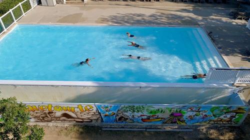 grupa ludzi pływających w basenie w obiekcie Charmant camping Familiale 3 Etoiles vue 360 plage piscine à débordement empl XXL w mieście Labeaume