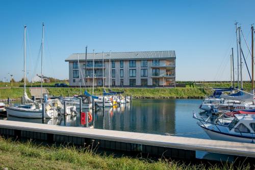 a bunch of boats docked in a marina with a building at Appartement voor 4 personen aan d'Ouwe Haven in Kamperland in Kamperland