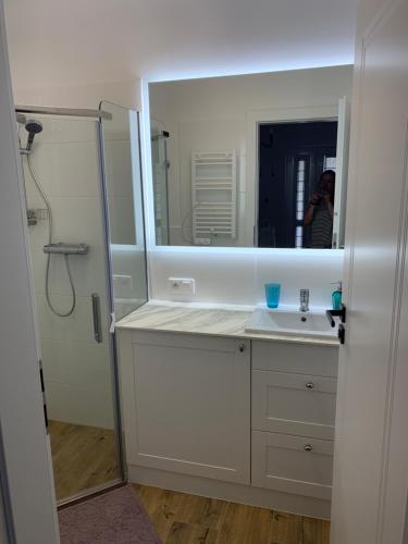 a person taking a picture of a bathroom with a mirror at apartament Wakacje w Rowach in Rowy