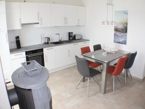 a kitchen with a table and chairs and a counter at Sonnengarten 19 in Kellenhusen