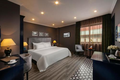 a bedroom with a large white bed and a desk at Matilda Boutique Hotel & Spa in Hanoi