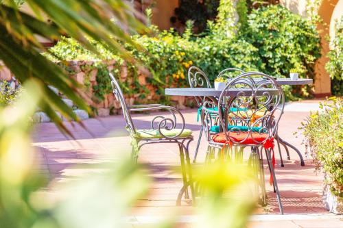 a group of chairs and a table and a table and chairs at Hotel Club Saraceno - Bovis Hotels in Àrbatax