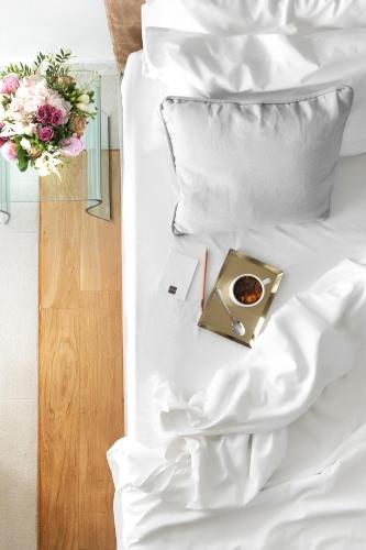 a tray of coffee on a bed with flowers at Daios Luxury Living in Thessaloniki