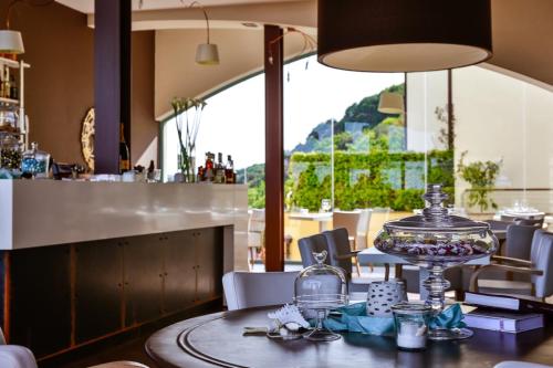 un restaurante con una mesa y un bar con vistas en Dominio Mare Resort & SPA, en Bergeggi