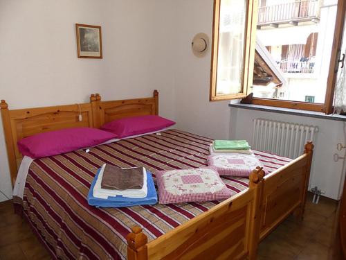 Una cama con mantas y almohadas encima. en Casa La Forsizia, en Valdieri