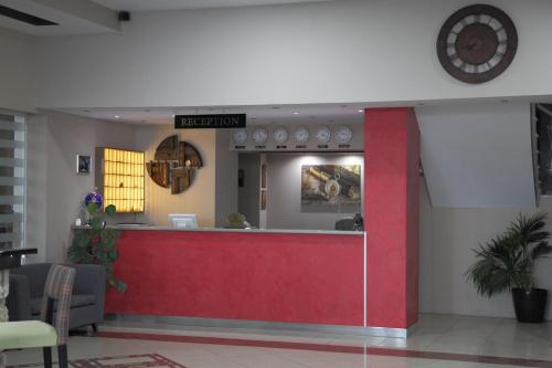 a restaurant with a red counter in a lobby at Evvoiki Akti Hotel in Politika