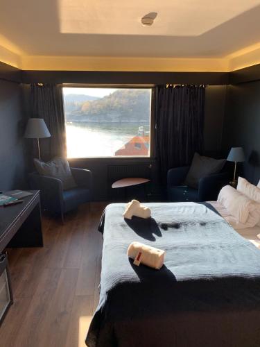 a hotel room with a large bed and a large window at Oscarsborg Castle Hotel & Resort in Drøbak