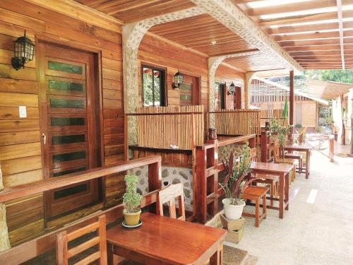 a restaurant with wooden walls and tables and chairs at Forest wood-Port Barton in San Vicente