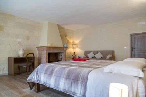 a bedroom with a large bed and a fireplace at Casal Dragone in Matera