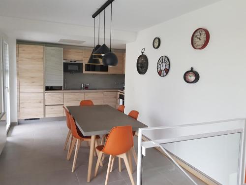 une cuisine et une salle à manger avec une table et des chaises dans l'établissement Appartement Duplex Jardin, à Sévrier