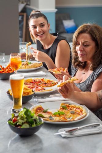 two women sitting at a table with plates of food at Best Western Sanctuary Inn in Tamworth