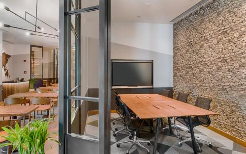 a conference room with tables and a tv on a brick wall at Shangri-La Colombo in Colombo