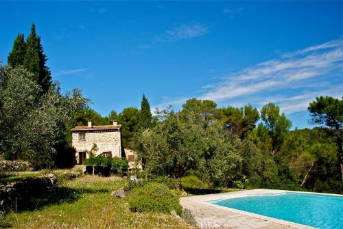 une petite maison en pierre à côté d'une piscine dans l'établissement Le Rayol, à Seillans