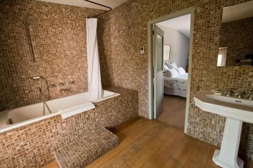 a bathroom with a bath tub and a sink at Maison Hache in Eygalières