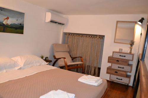 um quarto com uma cama e uma cadeira em City garden house em Lerápetra
