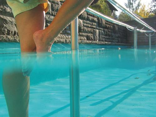 a person is standing in a swimming pool at Kurhotel Dornröschen in Bad Wörishofen