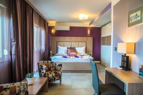 a hotel room with a bed and a chair at Anikol Apartments in Selce