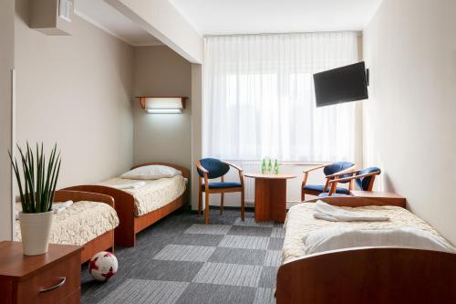 um quarto de hospital com duas camas e uma mesa e cadeiras em Hotel Zawisza em Bydgoszcz