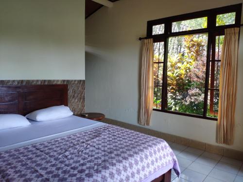 een slaapkamer met een bed en een raam bij Rijasa Homestay in Tirtagangga