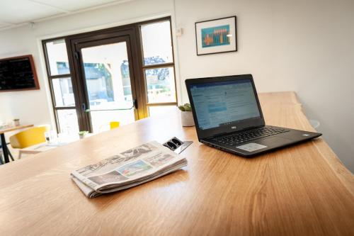 a laptop computer sitting on top of a wooden table at Campanile Beaune in Beaune