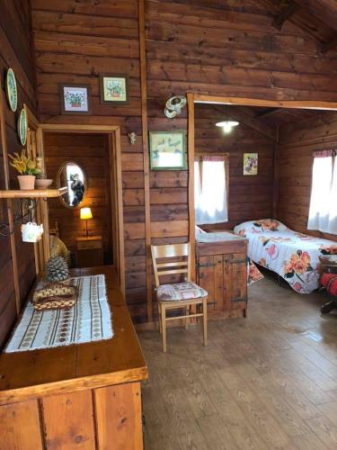 a log cabin with two beds and a table in it at CHALET ETNA MILO in Milo