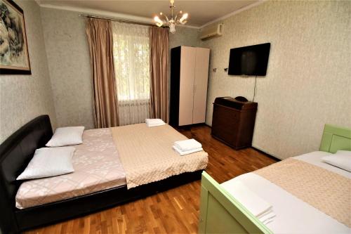 アドレルにあるДом для отпуска на Куйбышеваのベッド2台とテレビが備わるホテルルームです。