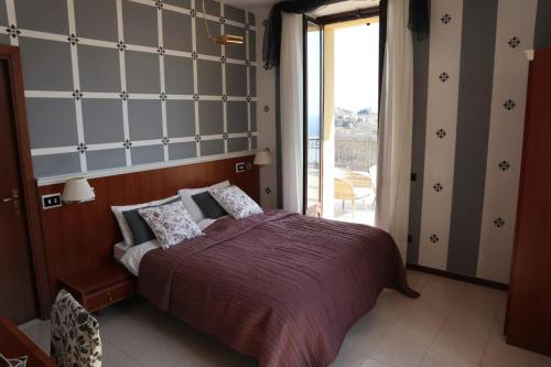 - une chambre avec un grand lit et un balcon dans l'établissement Villa Magnolia BB, Lago Maggiore (Massino Visconti, Italy), à Massino Visconti