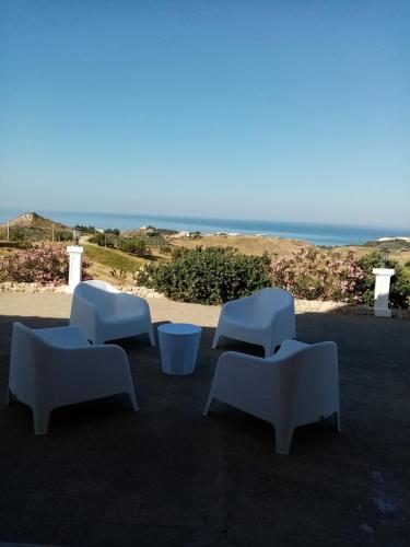 a group of white couches sitting on top of a patio at La valle degli dei in Eraclea Minoa