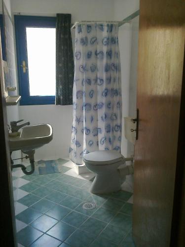 baño con aseo y lavabo y ventana en Appartement 4 pers, en Palaia Epidavros