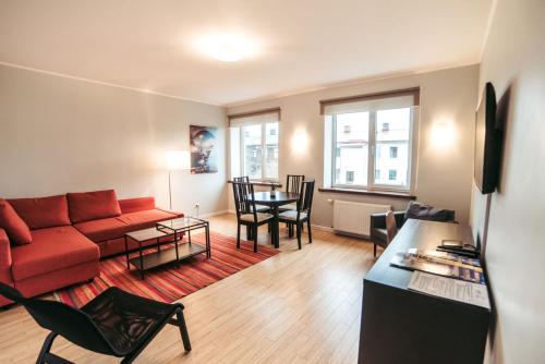a living room with a red couch and a table at 40 Saules in Ventspils