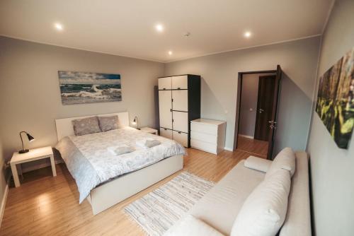 a bedroom with a bed and a couch at 40 Saules in Ventspils