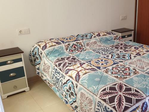 ein Schlafzimmer mit einem Bett und einem Nachttisch in der Unterkunft Primera linea del mar in Punta del Hidalgo