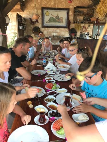 a group of people sitting around a table eating food at Beymelek Tas Evler in Demre