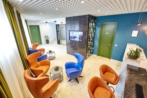 a waiting room with orange and blue chairs at Graphica Tbilisi Hotel in Tbilisi City