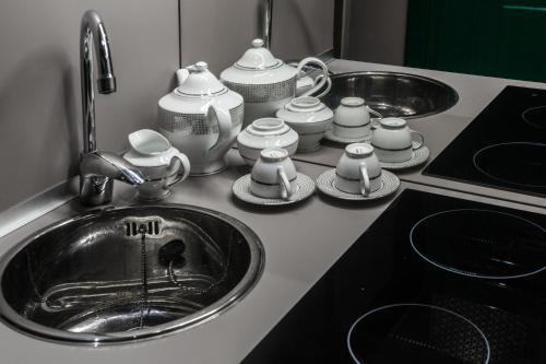 eine Küchentheke mit Spüle, Teekannen und Pfannen in der Unterkunft Piazza di Spagna Luxury Apartment in Rom