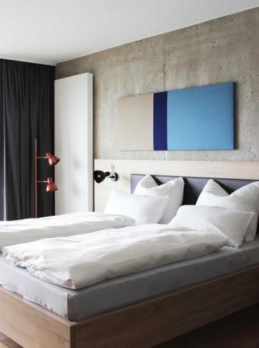 a bedroom with two beds with white pillows at Die Sandburg in Langeoog
