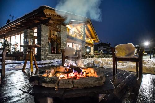 a fire pit in front of a house in the snow at Hotel Lo Campagnar in Courmayeur
