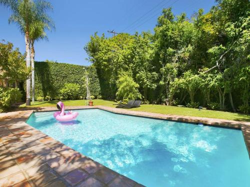 une piscine avec un cygne rose et un radeau rose dans l'établissement Villa Teresita - Beautifully gated Mediterranean estate, à Los Angeles