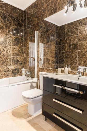 a bathroom with a toilet and a sink and a tub at Entre Mar e Mar in Aldeia do Meco