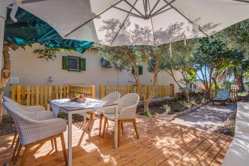 a patio with a table and chairs and an umbrella at Casa Rustica in Mali Lošinj