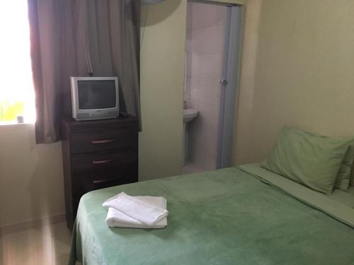 a bedroom with a bed and a tv on a dresser at Hospedaria Casa da Lia in Mucugê