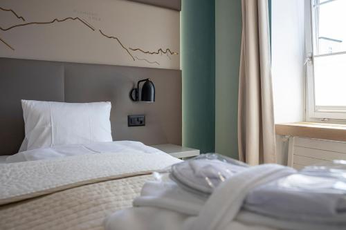 a bedroom with a bed with a chart on the wall at Hotel Rosatsch in Pontresina
