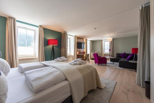 a bedroom with a large bed and a living room at Hotel Rosatsch in Pontresina