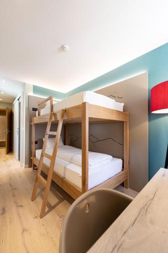 a room with two bunk beds in a room at Hotel Rosatsch in Pontresina