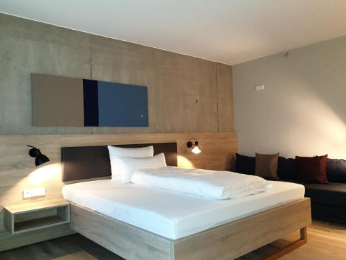 a bedroom with a large white bed and a couch at Die Sandburg in Langeoog