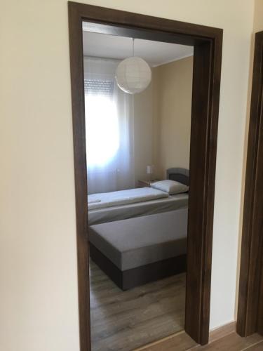 a mirror reflection of a bed in a bedroom at Konrad Apartman in Balatonmáriafürdő