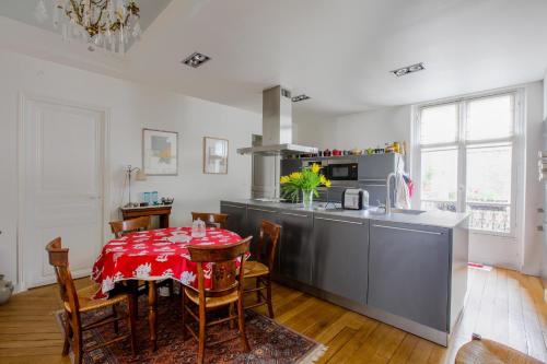 une cuisine avec une table et un chiffon rouge dans l'établissement Charming apartment - district Vaugirard by Weekome, à Paris
