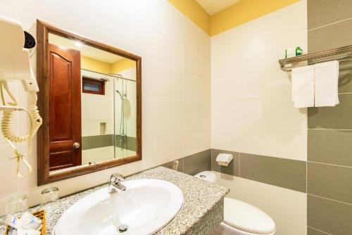 a bathroom with a sink and a toilet and a mirror at Sea Star Resort in Phú Quốc