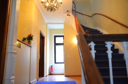 a hallway with a staircase and a chandelier at Hotel Villa Kisseleff in Bad Homburg vor der Höhe